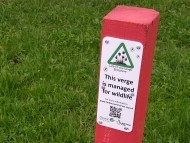 Post with a sign on it against a background of grass