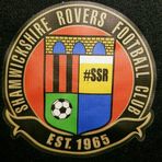 Shield with a representation of the bridge at the top and then the club colours quartered with a football and #SSR, encircled by the club name, and Est. 1965S